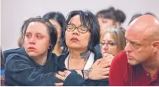  ?? EDDIE MOORE/JOURNAL ?? Angela Ortiz, surrounded by family members, reacts at a Monday court hearing to the 25-year prison sentence District Judge Francis Mathew set for the convicted killer of three of her family members.