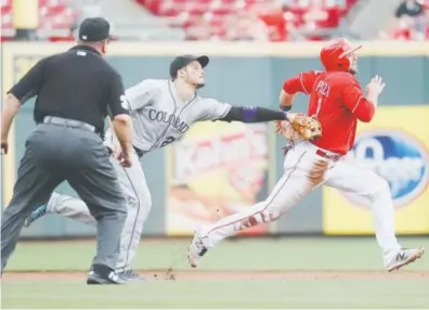  ??  ?? Rockies third baseman Nolan Arenado tags Reds baserunner Jose Peraza for an out during Sunday’s series finale at Great American Ball Park in Cincinnati. Arenado was chasing him back to second base. John Minchillo, The Associated Press