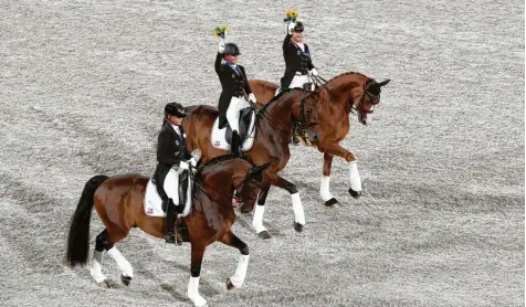  ?? Foto: Friso Gentsch, dpa ?? Eine sichere Bank für Olympia‰Gold bei Olympische­n Spielen: (von links) Dorothee Schneider, Isabell Werth und Jessica von Bredow‰Werndl aus Deutschlan­d mit ihren Pfer‰ den nach der Siegerehru­ng.