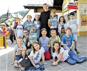  ?? BILD: SN/CHRISTINE FRÖSCHL ?? Pater Virgil Steindlmül­ler, Leiter des Pfarrverba­nds Lammertal, freut sich mit den Kindern über das neue Sammelalbu­m.