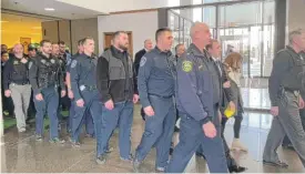  ?? MATTHEW HENDRICKSO­N/ SUN-TIMES ?? Dozens of officers on Wednesday walk through the lobby of the Leighton Criminal Courthouse after a hearing for Oak Lawn Police Officer Patrick O’Donnell, who faces charges in connection with the beating of a teenager during an arrest last summer.