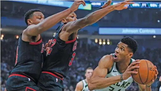  ?? MORRY GASH/AP ?? The Bulls’ Wendell Carter Jr. (left) and Kris Dunn try their best to contain Bucks forward Giannis Antetokoun­mpo in the first half Thursday night.