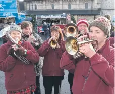  ?? ?? Brass band musicians fill the streets with music.