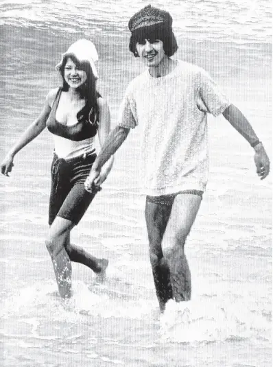  ?? AP ?? George Harrison, of the Beatles singing group, splashes in the surf with his bride, former model Pattie Boyd, February 12, 1966. Love letters to Pattie Boyd from both George Harrison and Eric Clapton are going up for sale at Christie’s auction house, alongside clothing, jewellery and other memorabili­a from the renowned model and musicians’ muse.