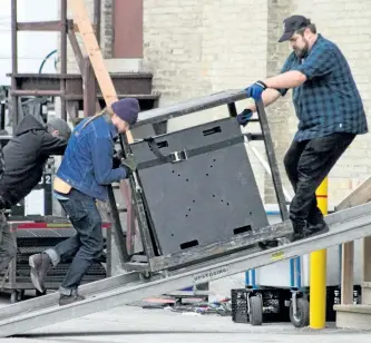  ?? JASON BAIN/EXAMINER ?? Crews work to move equipment in and around Coronation Hall on King Street in Omemee on Wednesday morning. Although the location has not been officially confirmed, Canadian rocker Neil Young is expected to perform a 90-minute solo acoustic concert that...