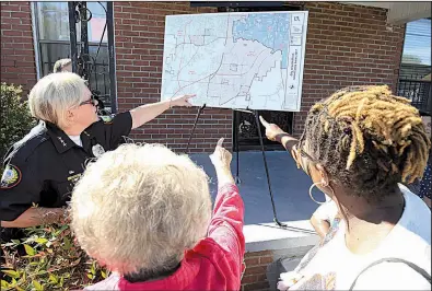  ?? Arkansas Democrat-Gazette/STATON BREIDENTHA­L ?? Little Rock Assistant Police Chief Alice Fulk, (from left) City Director Joan Adcock and Pamela Bingham, president of the Upper Baseline Windamere Neighborho­od Associatio­n, on Friday examine a map of areas where a grant will allow AmeriCorps members to...