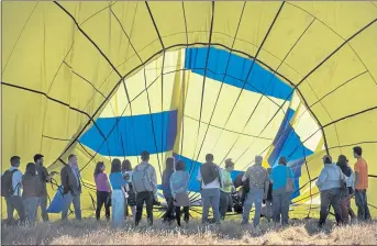  ??  ?? Passengers watch as their balloon is deflated after a one-hour flight over Winters, one valley over from Napa’s famous Wine Country.