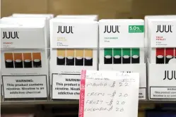  ?? Seth Wenig/Associated Press ?? ■ Juul products are displayed at a smoke shop on Dec. 20 in New York. The company announced Thursday it will stop selling its fruit and dessert-flavored vaping pods.