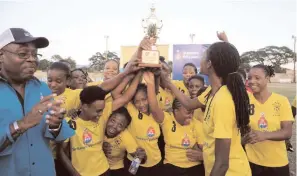  ?? FILE ?? Members of Barbican FC with the Sherwin Williams Women’s KO Trophy after they collected it from Ian Forbes (left), managing director of Sherwin Williams. Barbican defeated Waterhouse FC 4-1 in the final at the Spanish Town Prison Oval on December 6.