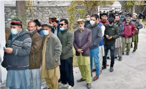  ??  ?? hOPe FOR BetteR DaYs: Voters stand in queue at a polling station in Gilgit on sunday. — APP