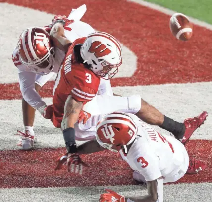  ?? TORK MASON / USA TODAY NETWORK-WISCONSIN ?? Indiana's Bryant Fitzgerald, left, and Tiawan Mullen break up a pass in the end zone intended for Wisconsin's Kendric Pryor on Saturday.