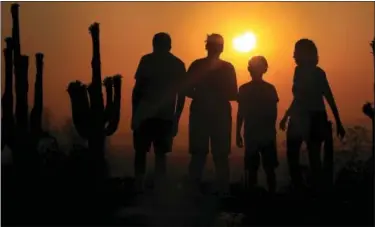  ?? ROSS D. FRANKLIN — THE ASSOCIATED PRESS FILE ?? People view an annular solar eclipse as they look towards the setting sun on the horizon in Phoenix.