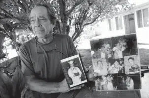  ?? The Associated Press ?? TERRORISM CHARGES: Clifford Kang, father of soldier Ikaika E. Kang, poses with photos of his son Monday in Kailua, Hawaii. Ikaika E. Kang, an active-duty U.S. soldier, was arrested over the weekend on terrorism charges that accuse him of pledging...