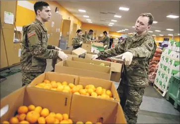  ?? Justin Sullivan Getty Images ?? STATE National Guard members at the Second Harvest Food Bank of Silicon Valley. The virus exploded in part because Santa Clara County was unable to track and trace its early spread, the county chief says.