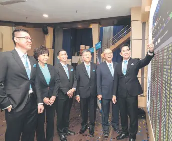  ?? ?? Lee (right) pointing at the board witnessed by his board of directors during Alpha IVF’s listing on the ACE Market of Bursa Malaysia yesterday.