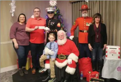  ?? LAUREN HALLIGAN ?? General manager Adam Hill and his wife Alison, left, present Sgt. Ted Kleniewski and “Gunny Claus” Robert Porter with a $1,000 donation to the 2018 Capital Region Toys for Tots campaign, during a Breakfast with Santa event where children got to meet Santa Claus. Also pictured: sales manager Michelle Moyer, right.