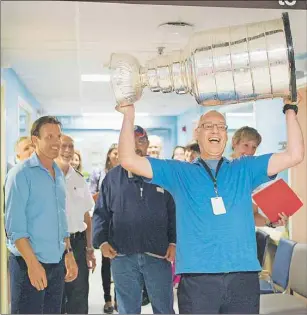  ?? BRIAN MCINNIS/THE GUARDIAN ?? Dr. Mitchell Zeman, pediatrici­an at the QEH, might be living a childhood dream as he lifts the Stanley Cup over his head Tuesday when Brad Richards visited the children’s ward at the hospital.