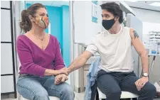  ?? ADRIAN WYLD THE CANADIAN PRESS FILE PHOTO ?? Sophie Grégoire Trudeau holds Prime Minister Justin Trudeau’s hand as he prepares to receive a COVID-19 vaccinatio­n in Ottawa last year.