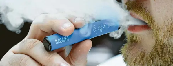  ?? Foto: Roberto Pfeil, dpa ?? Ein Raucher inhaliert eine Wegwerf-E-Zigarette der Firma Elf Bar. Seit der Einführung der Wegwerfpro­dukte ist die Nachfrage nach E-Zigaretten deutlich gestiegen.