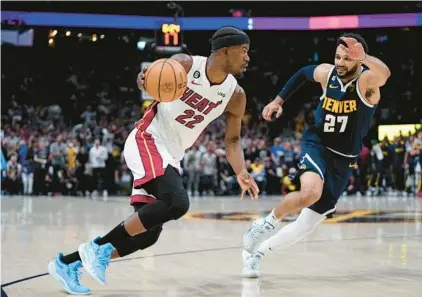  ?? MARK J. TERRILL/AP ?? Heat forward Jimmy Butler, left, drives against Nuggets guard Jamal Murray, right, during the first half of Game 2 of the NBA Finals on Sunday in Denver.