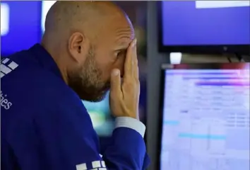  ?? Richard Drew/Associated Press ?? Specialist Meric Greenbaum works on the floor of the New York Stock Exchange on Monday. Stocks fell sharply as worries swept from Wall Street to Sydney that the worsening pandemic in hot spots around the world would derail a strong economic recovery.