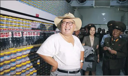  ?? KCNA VIA KNS ?? Kim Jong Un wears a close-fitting T-shirt to show he’s not concealing nuclear missiles during a tour of a fish pickling factory with wife Ri Sol Ju in South Hwanghae Province. He may wear the shirt to the leaders’ summit.