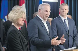  ?? SHAUGHN BUTTS ?? Steve Williams, president and CEO of Suncor, centre, with Alberta Premier Rachel Notley. Suncor shut down three of its oilsands facilities because of the wildfire.