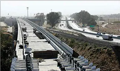  ?? PHOTOS BY RICH PEDRONCELL­I / AP ?? This 2019 file photo shows the high-speed rail viaduct parallelin­g Highway 99 near Fresno. Delays in securing land for California’s high-speed rail project will push completion of a section of the line in Kings County until at least April 2025. That’s nearly two years after the date the state included in a business plan adopted last week.