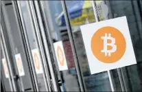  ?? MARK LENNIHAN/THE ASSOCIATED PRESS ?? In this April 7, 2014, file photo, Bitcoin logos are displayed at the Inside Bitcoins conference and trade show in New York.