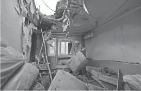  ?? AFP VIA GETTY IMAGES ?? A woman clears rubble in her daughter’s damaged apartment, which was hit by recent shelling in what local officials called a Ukrainian military strike in Donetsk, Russian-controlled Ukraine, on Thursday.