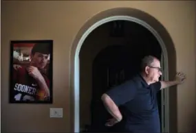  ?? AP PHOTO/JAE C. HONG ?? Doug Biggers, whose son, Landon, died of opioid overdose in 2017, pauses in his home office next to a framed photo of his son wearing his favorite jersey, in La Quinta, Calif., on Tuesday, Aug. 14, 2018. For months, Doug sat silently. He pretended when he could that it wasn’t real. He nailed two coat hooks to the wall in his home office and hung Landon’s jackets there, as though his son had just stopped by.