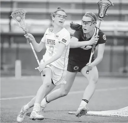  ?? KARL MERTON FERRON/BALTIMORE SUN ?? Johns Hopkins midfielder Maggie Friel tries to elude Penn State midfielder Kayla Brisolari in the first Big Ten women’s game played at Homewood Field. The Blue Jays (0-2) let down after halftime for the second straight league game. Penn State moved...