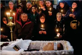  ?? Photograph: Reuters ?? Navalny’s parents, Lyudmila (C) and Anatoly (2nd L), sitting beside his open casket.