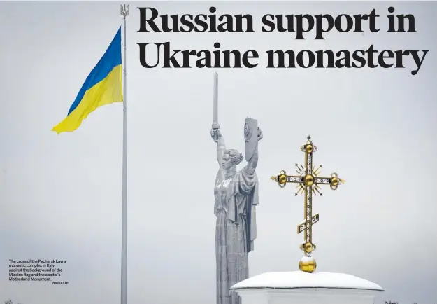  ?? PHOTO / AP ?? The cross of the Pechersk Lavra monastic complex in Kyiv, against the background of the Ukraine flag and the capital’s Motherland Monument.