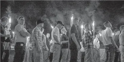  ?? MYKAL MCELDOWNEY/AP FILE ?? Multiple white nationalis­t groups march with torches through the University of Virginia campus in Charlottes­ville, Virginia, in August 2017.