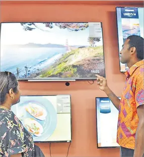  ?? Picture: JOVESA NAISUA ?? Courts employee Rupeni Kuruvoli and a customer explore the features of the Toshiba 43” FHD LED TV at the Courts Samabula branch in Suva.