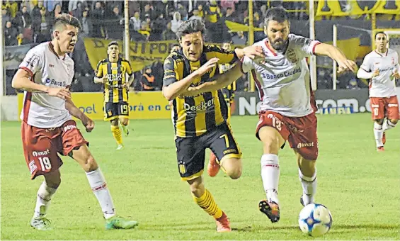  ??  ?? Encerrado. Pizzini intenta escaparse entre Villalba y Romat, quien participó de la polémica jugada en la que el árbitro le dio un penal a Olimpo.