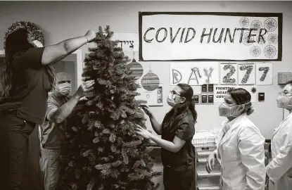  ?? Godofredo A. Vásquez / Staff photograph­er ?? Dr. Joseph Varon, chief medical officer at Houston’s United Memorial Medical Center, and his medical staff set up a Christmas tree Monday inside the COVID-19 intensive care unit. Similar scenes are happening nationwide this week.