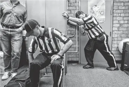  ?? PHOTOS BY PATRICK BREEN/THE REPUBLIC ?? Officials Aaron Hochuli (seated) and Dean Cerimeli prepare for a game at Marcos de Niza High School in Tempe on Oct. 31. Many officials pack two striped shirts so they can change at halftime, especially during sweltering early-season games.