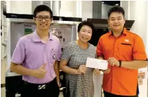  ??  ?? Director of SK Lifetyle (Miri), Johnny Wong (right) symbolical­ly hands over sponsored products to See Hua Marketing sales representa­tives Yii Mii Siew and Melvin Ng (left).