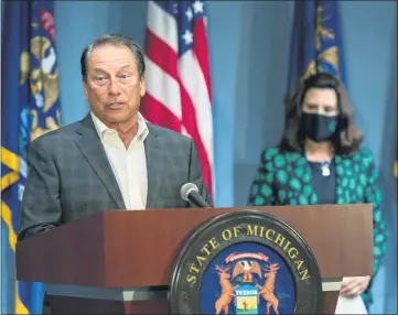  ?? MICHIGAN OFFICE OF THE GOVERNOR VIA AP ?? Michigan State men’s basketball coach Tom Izzo, standing next to Gov. Gretchen Whitmer, addresses the state, Wednesday, July 15, in Lansing. Izzo, women’s coach Suzy Merchant and University of Michigan women’s coach Kim Barnes Arico joined the governor her at a news conference to push mask wearing.