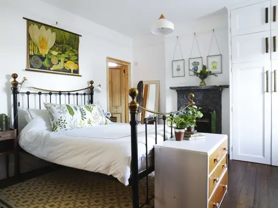  ??  ?? ABOVE In the master bedroom a vintage botanical wall chart hangs above the iron bedstead, which is a replica of a Victorian design RIGHT A silk Persian rug and English Victorian bedroom chairs upholstere­d in gold velvet give Verity’s bedroom a...