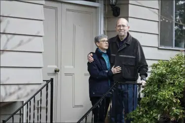  ?? TED S. WARREN — THE ASSOCIATED PRESS ?? Bob and Pat McCauley pose for a photo on their front porch March 6 at their home in Kirkland, Wash. The couple has been self-quarantine­d in their home during the past week due to having visited friends at the Life Care Center nursing home, which has become the epicenter of the outbreak of the COVID-19 coronaviru­s in Washington state.