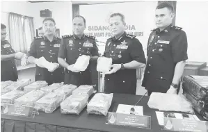  ?? ?? RAMPASAN TERBESAR: (Dari kiri) Alexson, Ibrahim dan Mancha menunjukka­n dadah disyaki syabu yang berjaya dirampas di Miri pada sidang media media di IPD Miri, semalam.