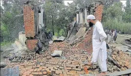  ?? AP ?? A villager inspects the debris of one of the houses damaged in a gunbattle in Pulwana district on Tuesday. Two militants — Jehangir Ahmad and Kifayat Khanday were killed on Monday while a third militant was gunned down on Tuesday evening bringing an end to the 24hour gun battle. Reports also said several civilians had been injured in clashes with the security forces as they tried to pelt stones at them to disrupt the antiterror operation.