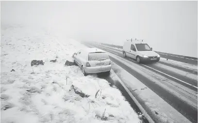  ?? — Gambar AFP ?? LUAR BIASA: Sebuah kereta tersadai di tepi jalan setelah terbabas ke kawasan berbatu di salah satu jalan luar bandar di Derbyshire, utara England kelmarin.