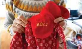  ?? ?? Bokja Hansen holds the uniform from Holt Children’s Services, which she wore when she arrived in Denmark from South Korea aged five. Photograph: Ye Ming