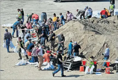  ?? [ORLIN WAGNER/THE ASSOCIATED PRESS] ?? Volunteers fill sandbags Monday in preparatio­n for flooding along the Missouri River in St Joseph, Mo.