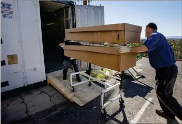  ?? PHOTO BY KARL MONDON — STAFF ARCHIVES ?? Charles Martinez, left, and Todd Larsen use an auxiliary refrigerat­or unit to store bodies at Evergreen Cemetery in Oakland. While Bay Area death rates were low, the cemetery handled some of the overflow from other counties.