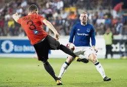  ?? — AP ?? No way through: Everton’s Wayne Rooney (right) attempts to block a shot from Ruzomberok’s Jan Maslo in the Europa League qualifying third round, second leg match in Ruzomberok, Slovakia, on Thursday.